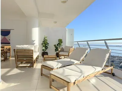 a room with chairs and tables on a balcony at Breathtaking Sea and Marina View City Center 2 bdr in Larnaka