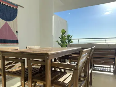 a wooden table and chairs in a room at Breathtaking Sea and Marina View City Center 2 bdr in Larnaka