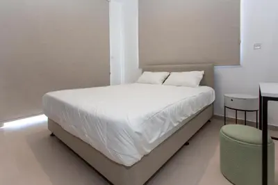 a bed with white sheets and pillows in a room at BlueStar Limassol Suites in Limassol