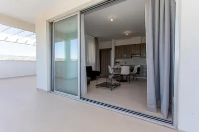 a large glass window in a living room with a dining room at BlueStar Limassol Suites in Limassol