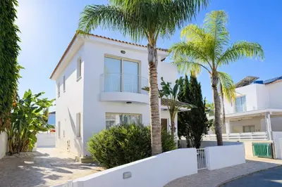 a white house with palm trees in front of it at Villa Dolce Vita II in Protaras