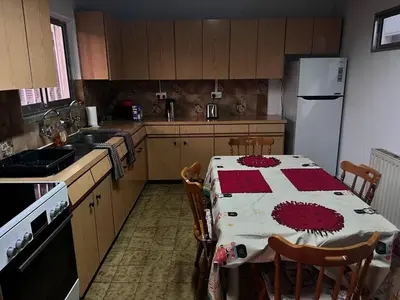 a kitchen with a table and a white refrigerator at Mountain Retreat in Kakopetria, Cyprus - Perfect for Families in Kakopetria