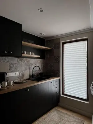 a kitchen with black cabinets and a window with a sink at Aprosmeno Jacuzzi House 6 in Agros