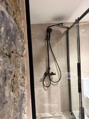 a shower with a hose hanging from a wall at Aprosmeno Jacuzzi House 6 in Agros
