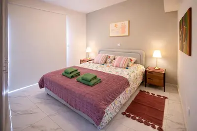a bedroom with a bed with two green pillows on it at Mythical Sands 2 - G in Aglantzia