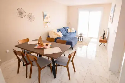 a living room with a table and a blue couch at Mythical Sands 2 - G in Aglantzia