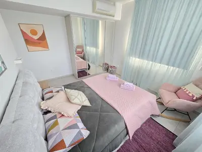 a bedroom with a bed with a mirror and pink blankets at Mythical Sands 2 - B in Paralimni