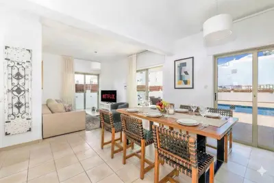 a dining room and living room with a table and chairs at Fig Tree Beach Villa Two in Paralimni