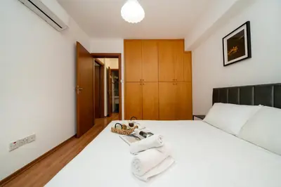 a bedroom with a white bed with towels on it at 2 bedroom flat in center in Nicosia