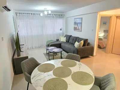 a living room with a table and a couch at Thea Court 1 - A in Paralimni
