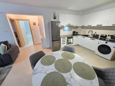 a living room with a table and a kitchen at Thea Court 1 - A in Paralimni