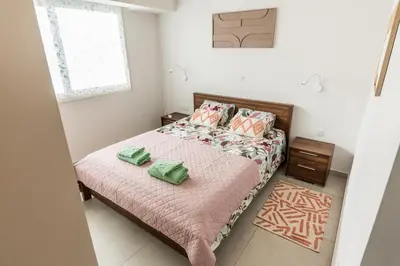 a bedroom with a bed with two green towels on it at Mythical Sands 2 - F in Paralimni