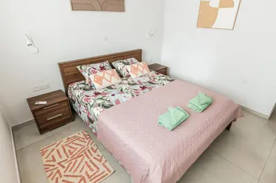 a small bedroom with a bed and a night stand at Mythical Sands 2 - F in Paralimni