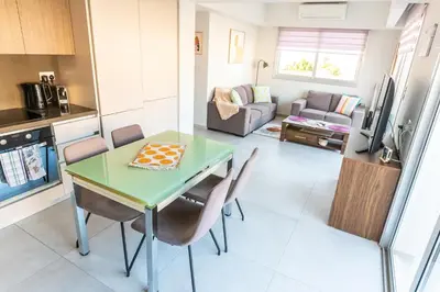 a kitchen and living room with a table and chairs at Mythical Sands 2 - E in Paralimni
