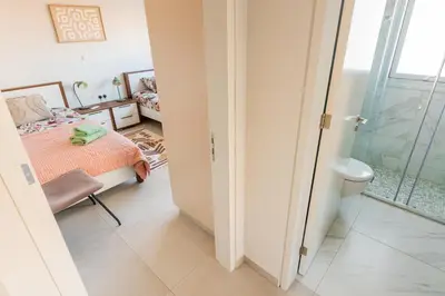 a bedroom with a bed and a bathroom with a shower at Mythical Sands 2 - E in Paralimni