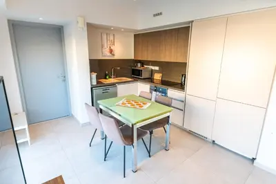 a small kitchen with a green table and chairs at Mythical Sands 2 - E in Paralimni