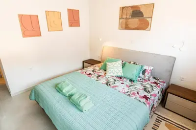 a bedroom with a bed with green pillows on it at Mythical Sands 2 - E in Paralimni