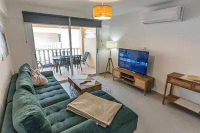 a living room with a green couch and a television at Thea Court 3 - E in Paralimni