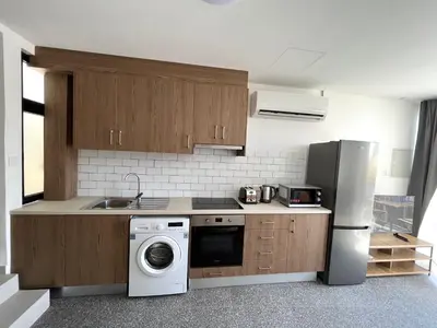a kitchen with a refrigerator and a washing machine at Unique 2 storey apt city centre in Larnaka