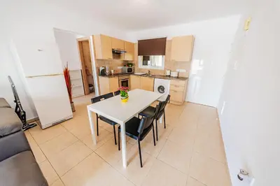a kitchen with a white table and chairs in a room at Nissia Bella 1 - A in Ayia Napa
