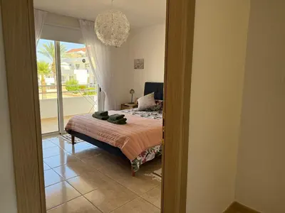 a bedroom with a bed and a view of a balcony at Nissi 3, 1 -B in Ayia Napa