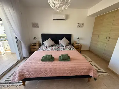 a bedroom with a large bed with two green pillows at Nissi 3, 1 -B in Ayia Napa