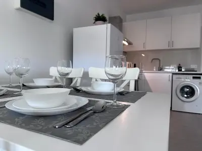 a kitchen with a table with plates and wine glasses at Amore 1 - A in Paralimni