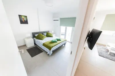 a bedroom with a bed with green pillows at Amore 1 - A in Paralimni