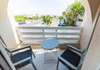 a balcony with two chairs and a table and a window at Amore 1 - A in Paralimni