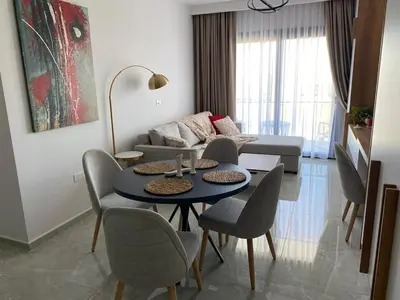 a living room with a table and chairs and a couch at Sunrise 80 in Aglantzia