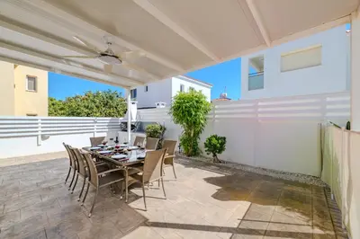 a dining room with a table and chairs on a patio at Ayia Triada Beach Gardens in Protaras