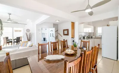 a kitchen and living room with a dining room and a table at Ayia Triada Beach Gardens in Protaras