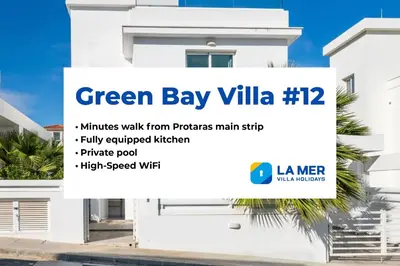 a white house with a banner for green bay villa at Green Bay Villa #12 in Protaras