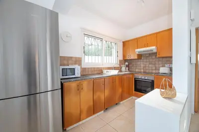 a kitchen with wooden cabinets and a stainless steel refrigerator at Blue Horizon Villa in Protaras