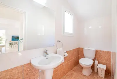 a bathroom with a white toilet and a sink at Blue Horizon Villa in Protaras