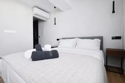 a bedroom with a white bed with a stuffed animal on it at Sky Suites Nicosia in Strovolos