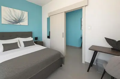 a bedroom with a bed and a desk and a chair at Modern 1BR with City View in Central Larnaca in Larnaka