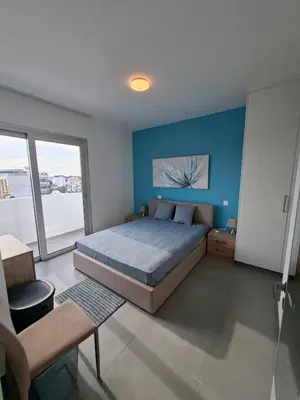 a bedroom with a bed and a blue wall at Luxury central 1BR with city view in Larnaka