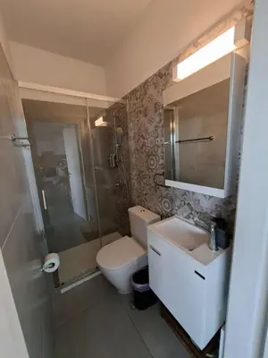 a bathroom with a toilet and a sink and a shower at Luxury central 1BR with city view in Larnaka