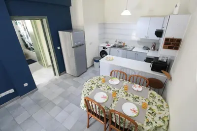 a kitchen with a table and chairs and a kitchen with a table and a table at Cozy flat by the sea with big pool tourist area in Limassol