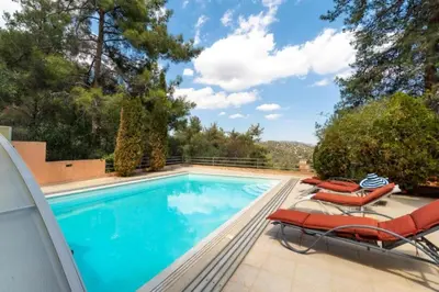 a swimming pool with two lounge chairs and a swimming pool at STAY Hillcrest Panorama Villa in Moniatis