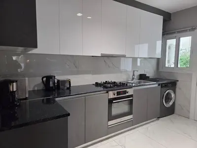 a kitchen with white cabinets and a stove top oven at Pop Art Residence by Staycom in Nicosia