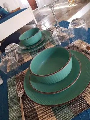 a table with green plates and forks and glasses at Cottage Studio Zoe in Psematismenos