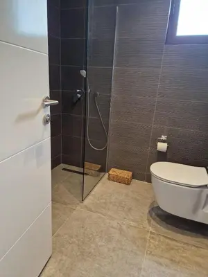 a bathroom with a toilet and a glass shower at Kantara Beach Resort Apartment Olivia in Aglantzia