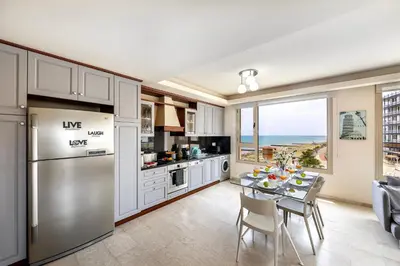 a kitchen and dining room with a table with chairs at Mackenzie Beachfront Eftyhia Suite in Larnaka