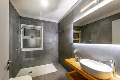 a bathroom with a sink and a shower at Mackenzie Beachfront Eftyhia Suite in Larnaka