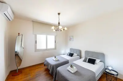 a bedroom with two beds and a window at Mackenzie Beachfront Eftyhia Suite in Larnaka