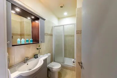 a bathroom with a sink and a toilet and a shower at Mackenzie Beachfront Eftyhia Suite in Larnaka