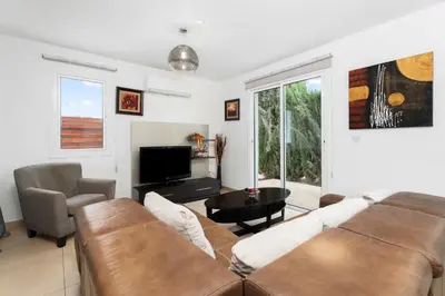a living room with a couch and a tv at Villa Anais - 3-Bed Villa with Private Pool in Paralimni