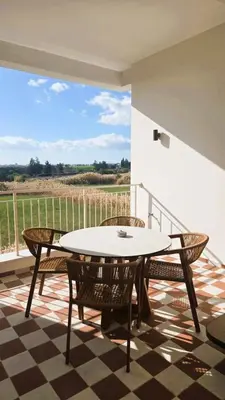a patio with a table and chairs on a balcony at 1BR Serviced Apt with Pool & Premium Amenities in Voroklini